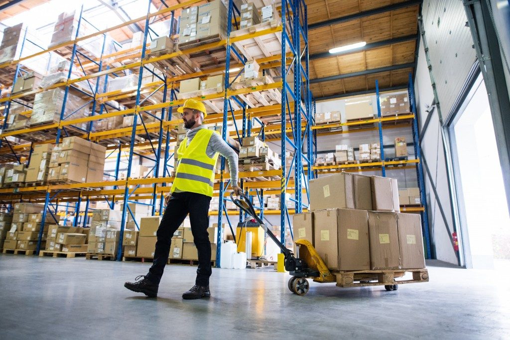 employee wearing safety hat and vest while working inside the warehouse