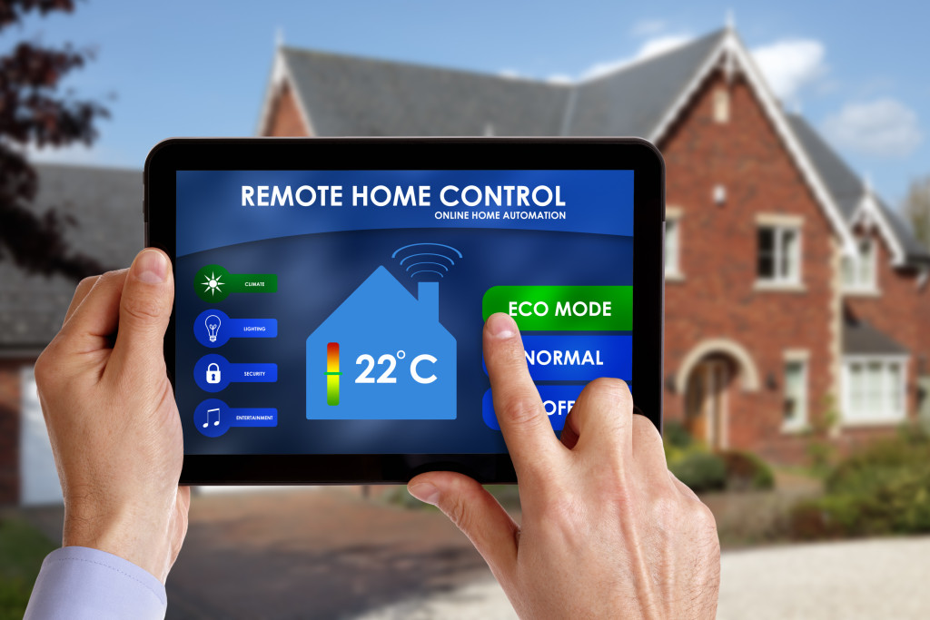 Holding a smart energy controller or remote home control online home automation system on a digital tablet.